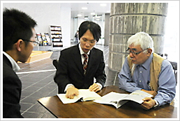 キョウユウ菊池と、本をご覧になる大野照文氏と蒲生諒太氏